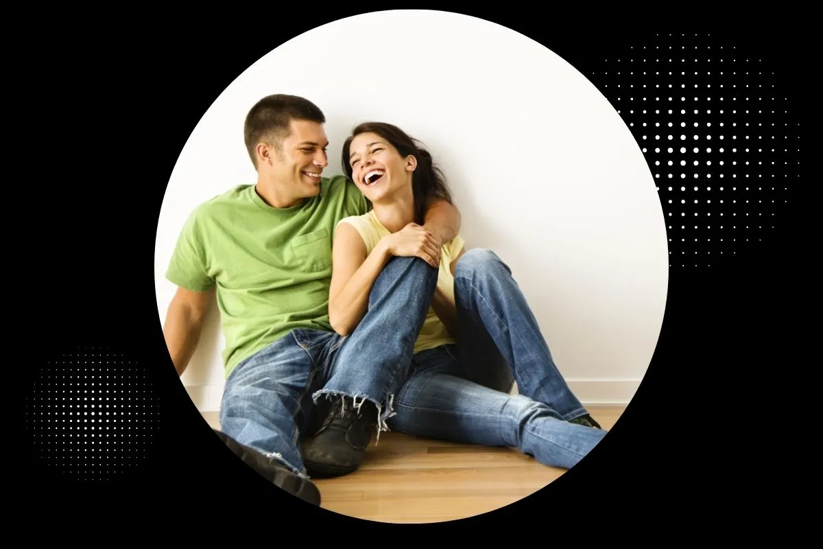 happy couple sitting on wood floor