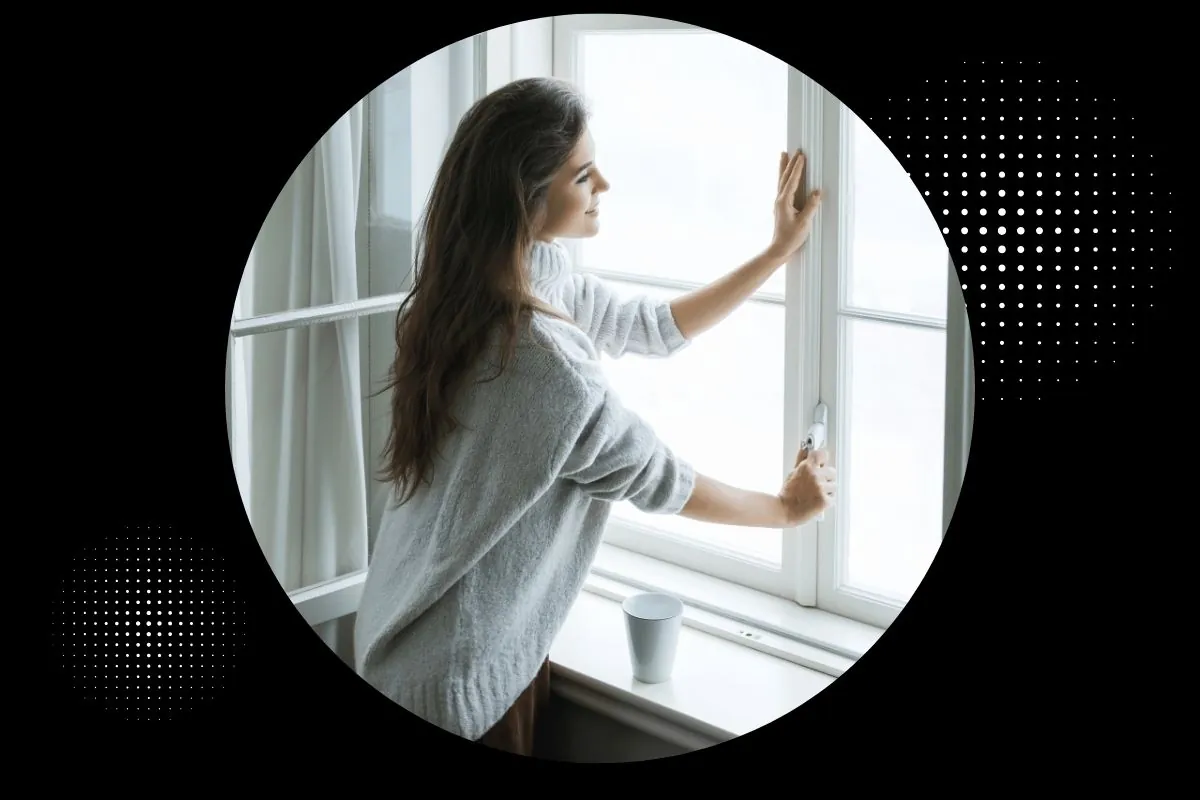 woman in warm woolen pullover is opening window